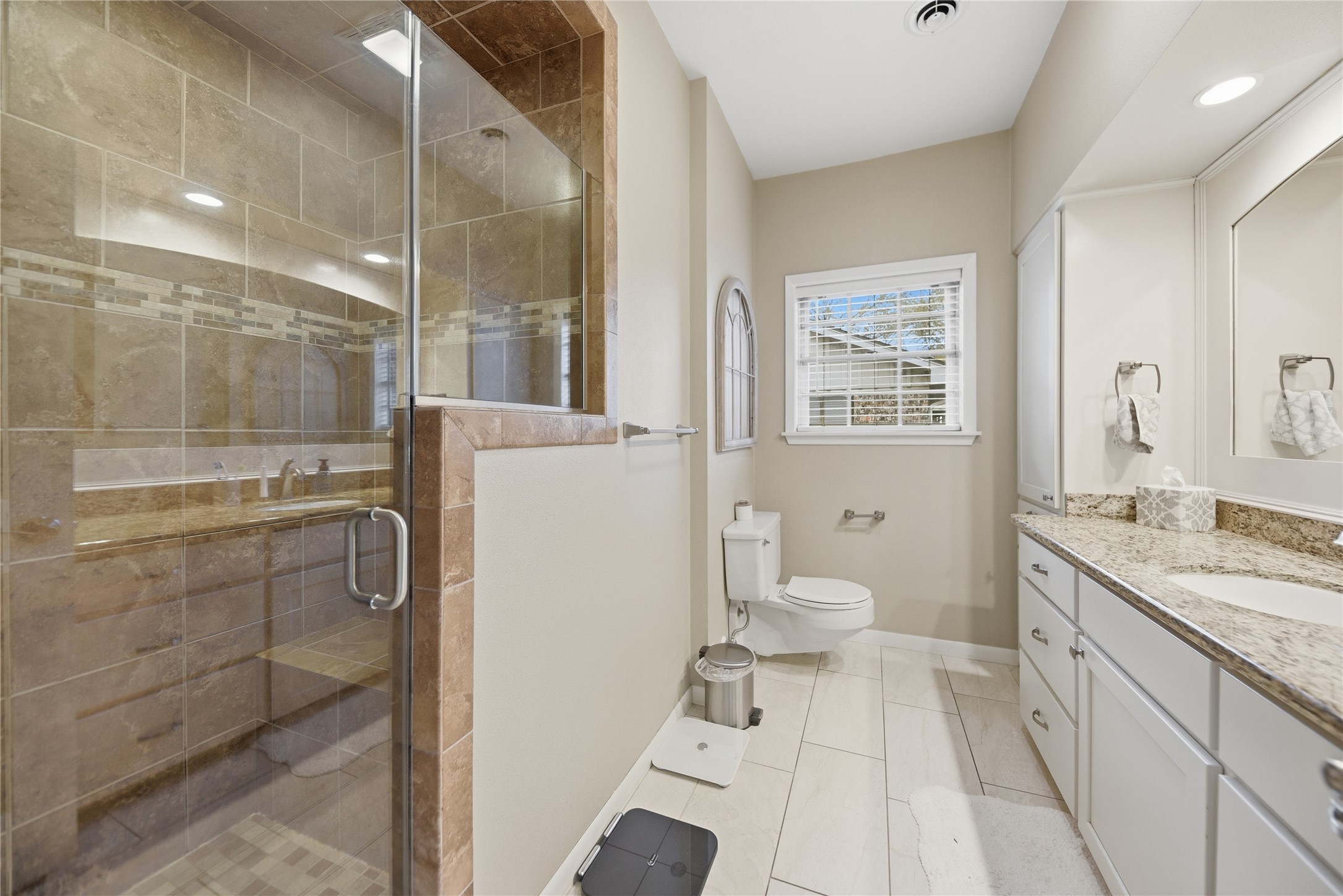 2007 Geney Street Brenham, TX 77833 - Photo 11 of 18 a bathroom with a granite countertop toilet a sink and a shower