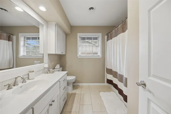 a spacious bathroom with a double vanity sink a mirror and a bathtub