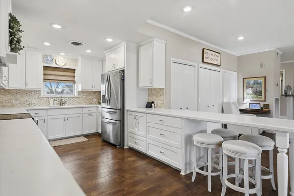 a kitchen with white cabinets and stainless steel appliances