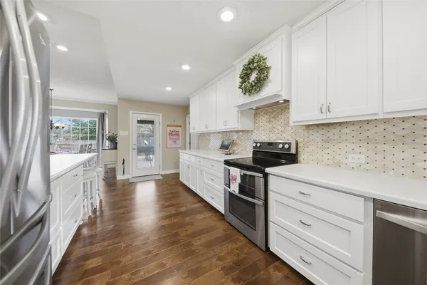 a kitchen with granite countertop white cabinets and white appliances