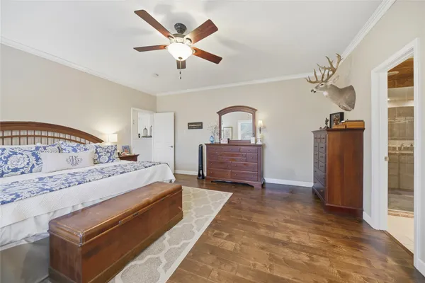 a spacious bedroom with a bed ceiling fan and a window