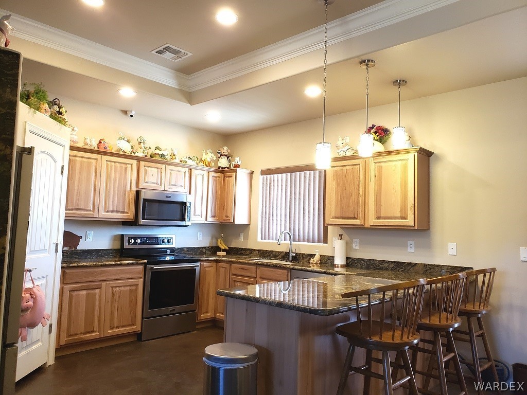 3681 Bacobi Road Golden Valley, AZ 86413 - Photo 5 of 17 a kitchen with kitchen island granite countertop a sink cabinets and stainless steel appliances