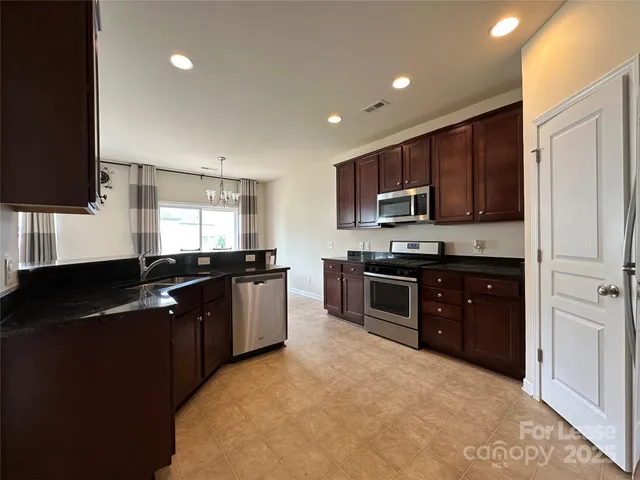 a kitchen that has a lot of cabinets and stainless steel appliances
