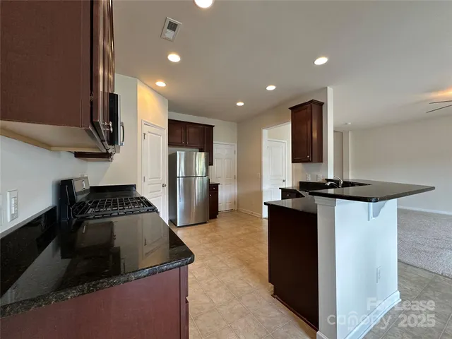 a kitchen with granite countertop a sink and a stove top oven