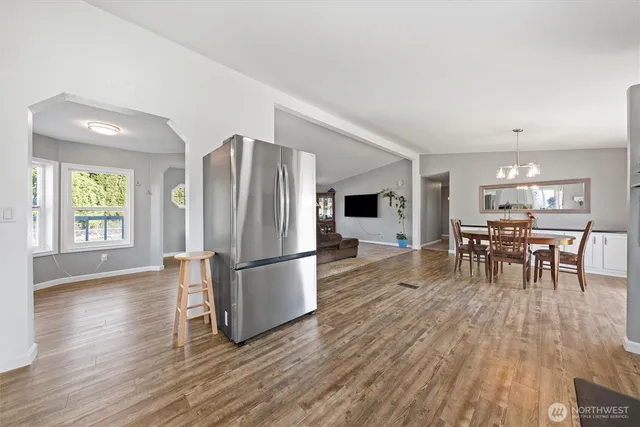 a kitchen with stainless steel appliances granite countertop a refrigerator microwave and wooden floor