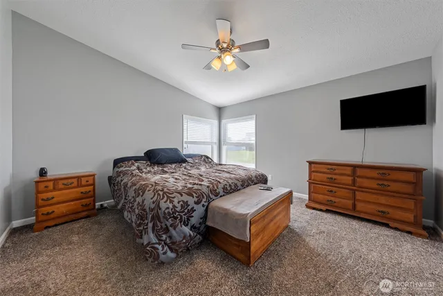 a bedroom with a bed a flat screen tv and dresser