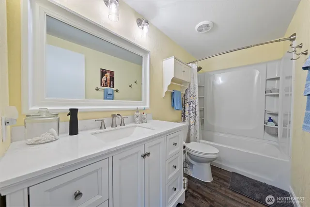 a bathroom with a granite countertop sink toilet and shower