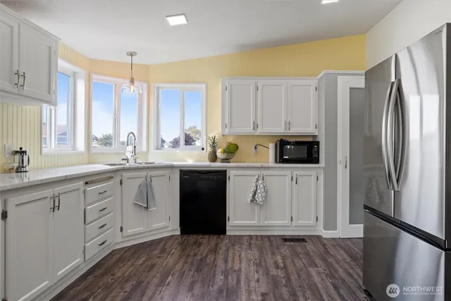 a kitchen with a refrigerator sink and cabinets