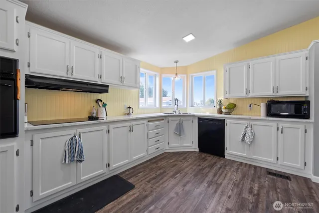 a kitchen with granite countertop white cabinets and white appliances