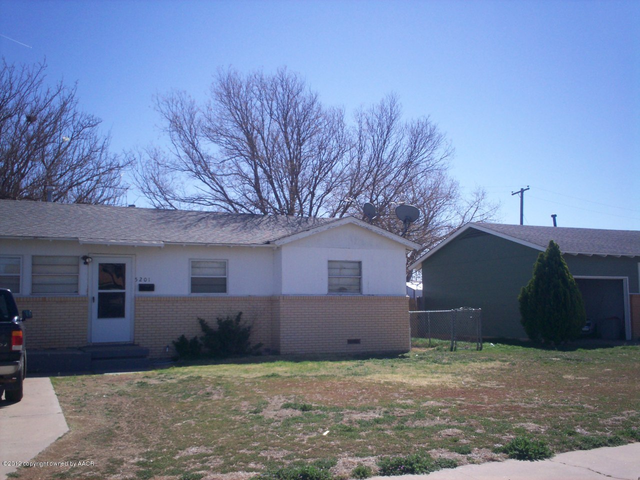 5201 South Travis Street Amarillo, TX 79110 - Photo 14 of 20 a front view of a house with a yard and garage