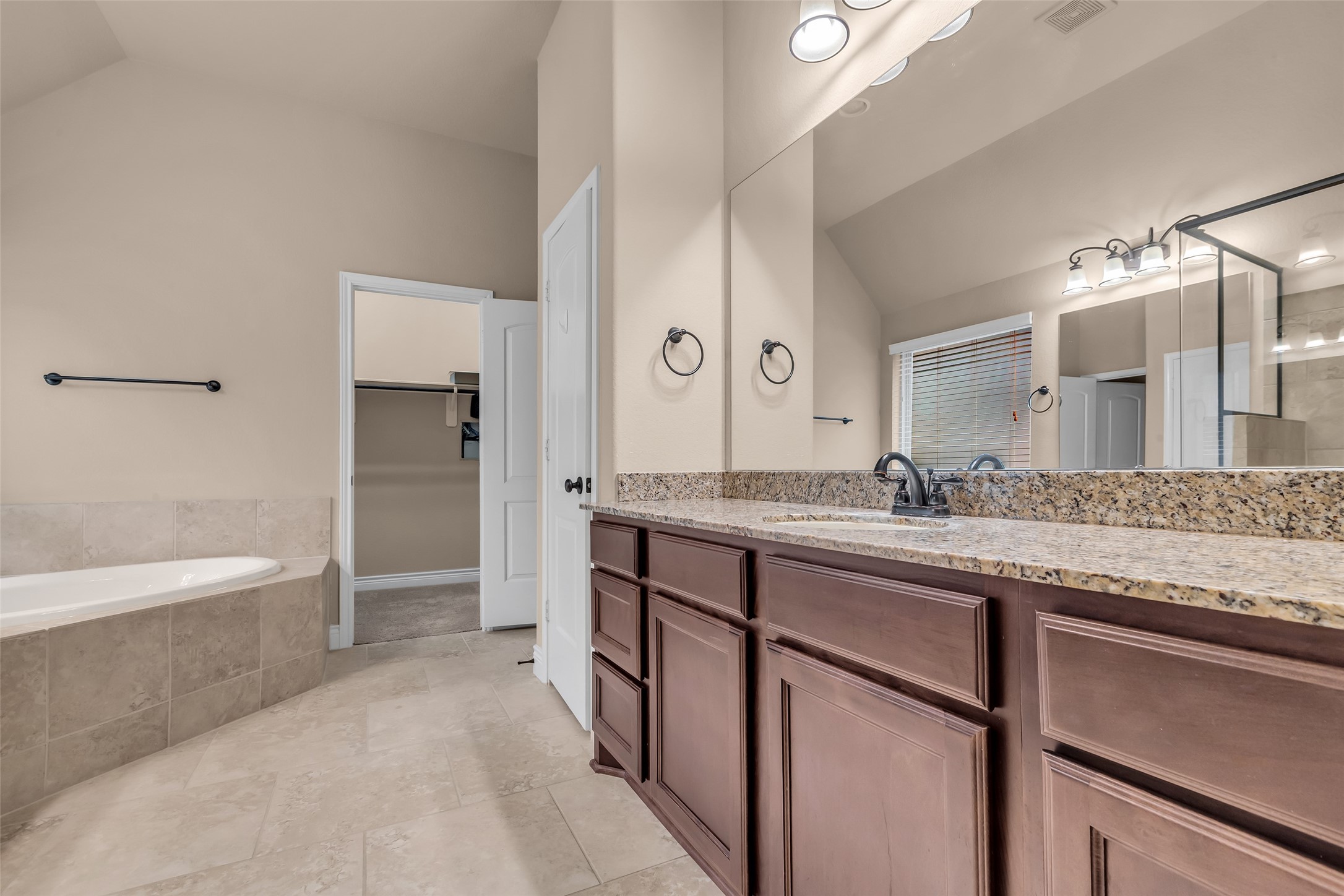 27946 Emory Cove Drive Spring, TX 77386 - Photo 18 of 25 a bathroom with a granite countertop sink mirror and a bathtub