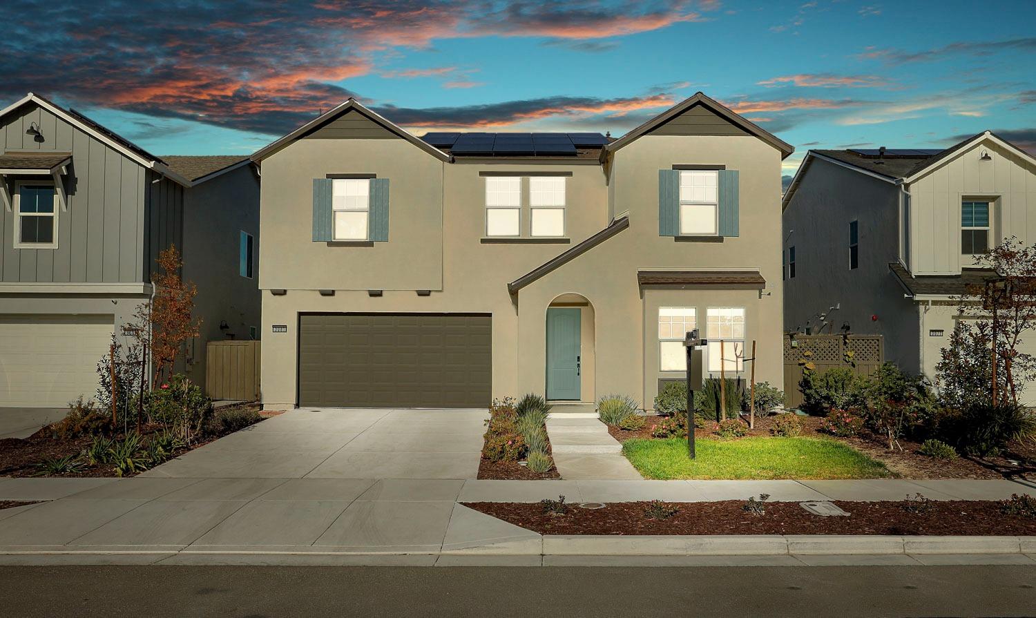 a front view of a house with a yard and garage