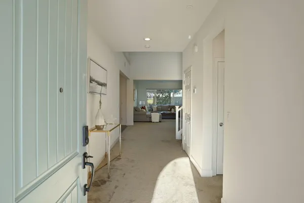 a view of a hallway with a livingroom and a chair