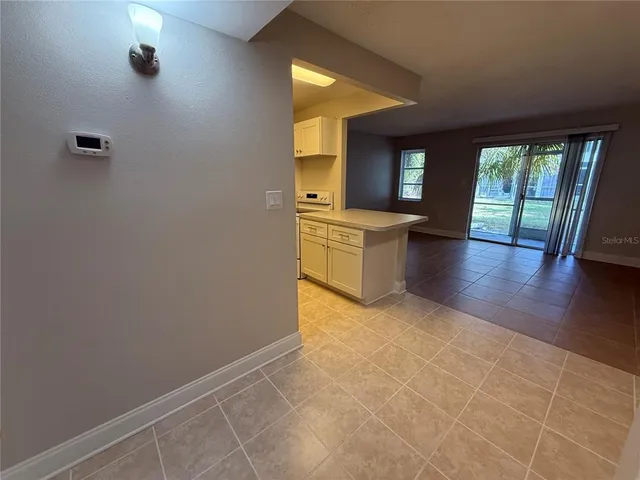 a view of a kitchen with wooden floor and a window
