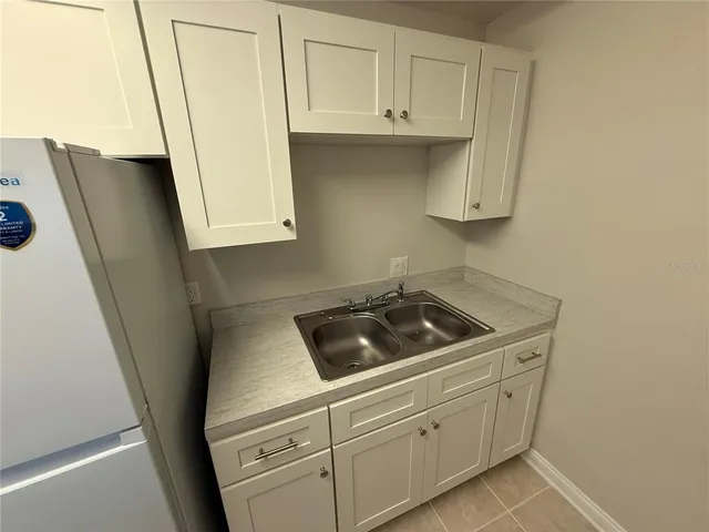a kitchen with white cabinets and white appliances