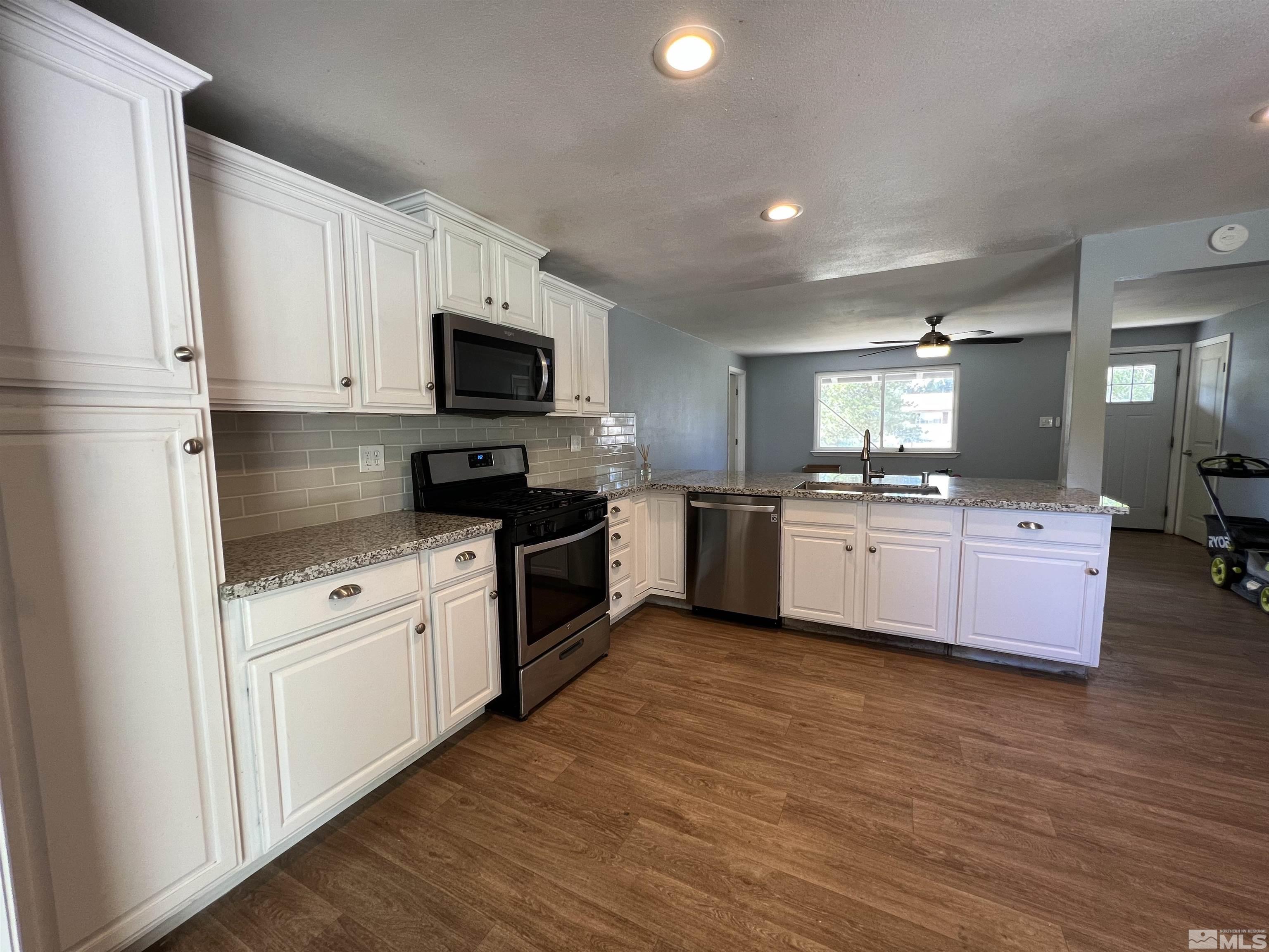 9120 Fremont Way Reno, NV 89506 - Photo 5 of 15 a kitchen with granite countertop a sink cabinets and stainless steel appliances