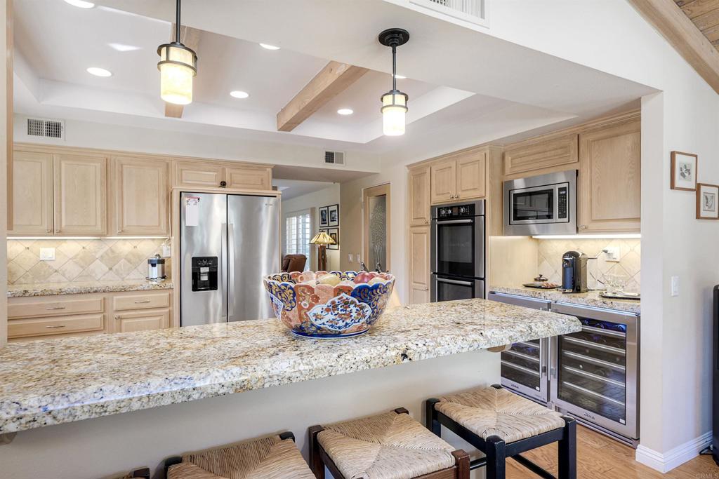 16142 El Tae Road Pauma Valley, CA 92061 - Photo 12 of 63 a kitchen with stainless steel appliances kitchen island granite countertop a stove refrigerator and cabinets