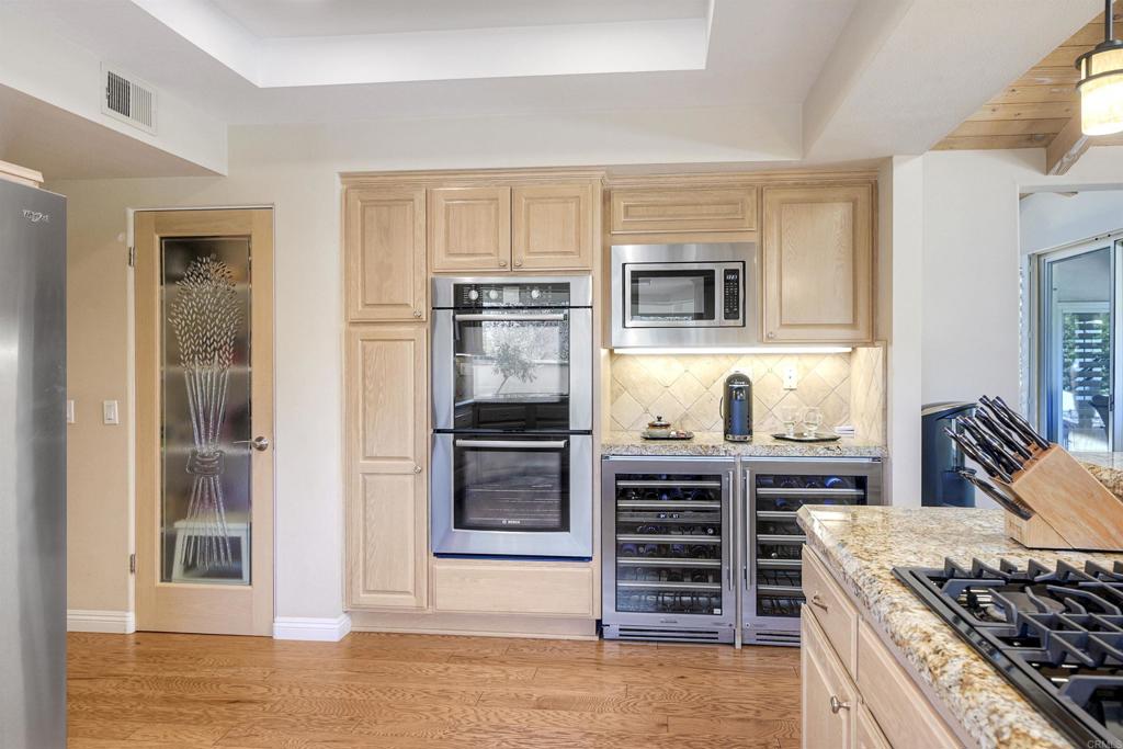16142 El Tae Road Pauma Valley, CA 92061 - Photo 13 of 63 a kitchen with stainless steel appliances kitchen island granite countertop a stove and a refrigerator