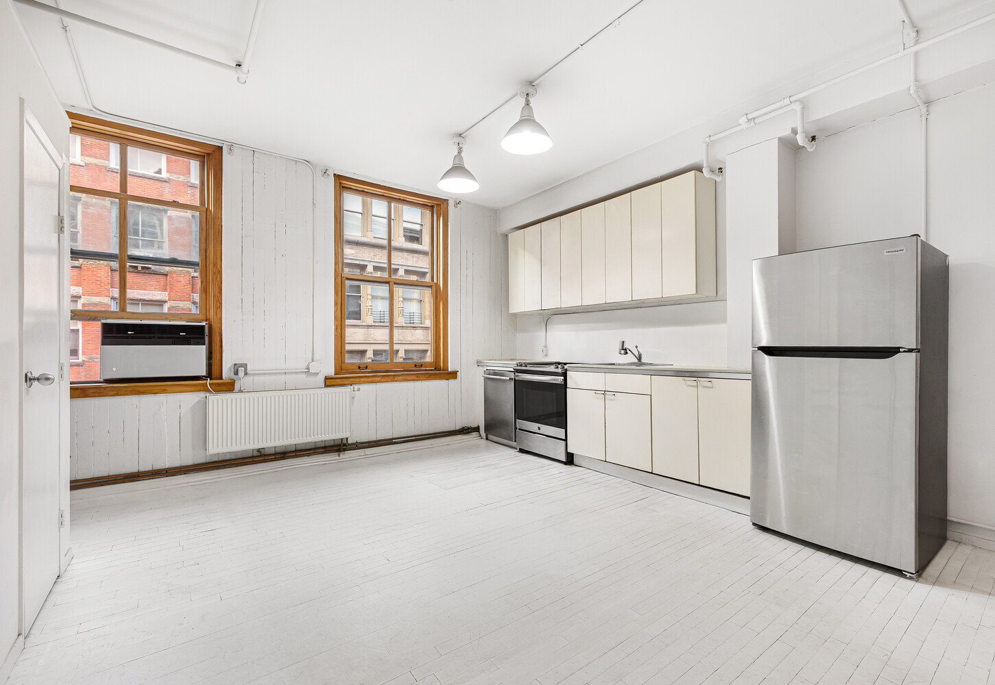 108 Wooster Street, Unit 3A Manhattan, NY 10012 - Photo 3 of 10 a view of kitchen with stainless steel appliances granite countertop white cabinets and window