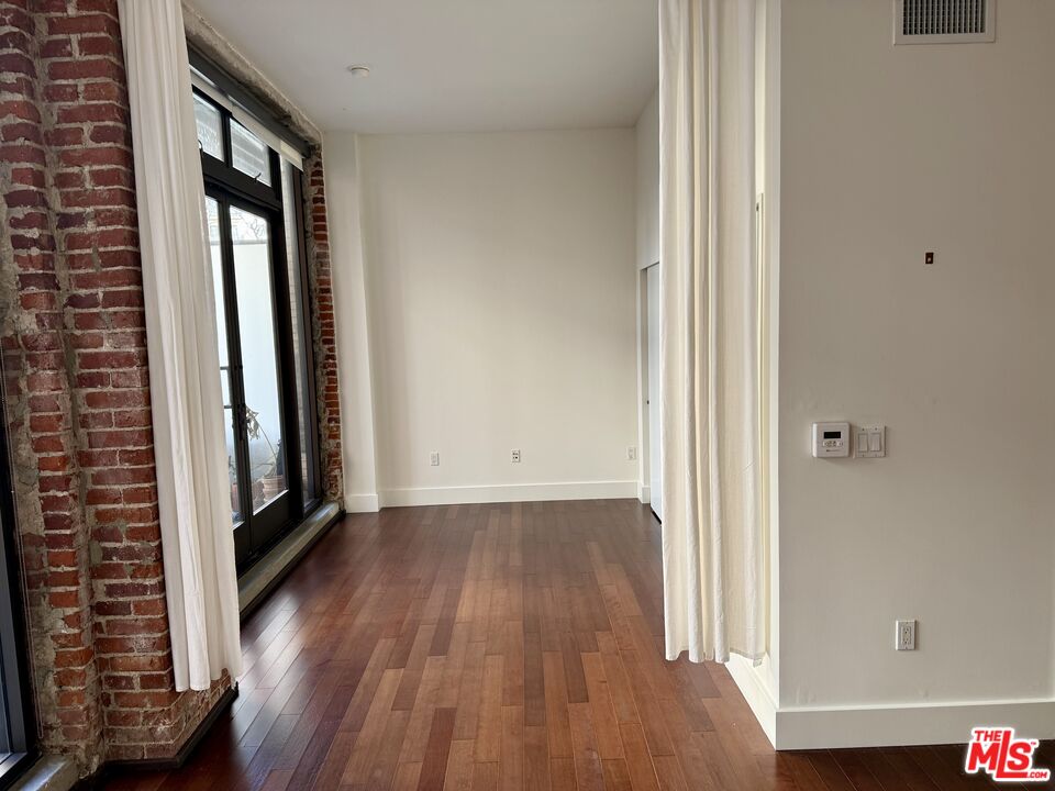 460 South Spring Street, Unit 205 Los Angeles, CA 90013 - Photo 15 of 18 a view of an empty room with wooden floor and a window