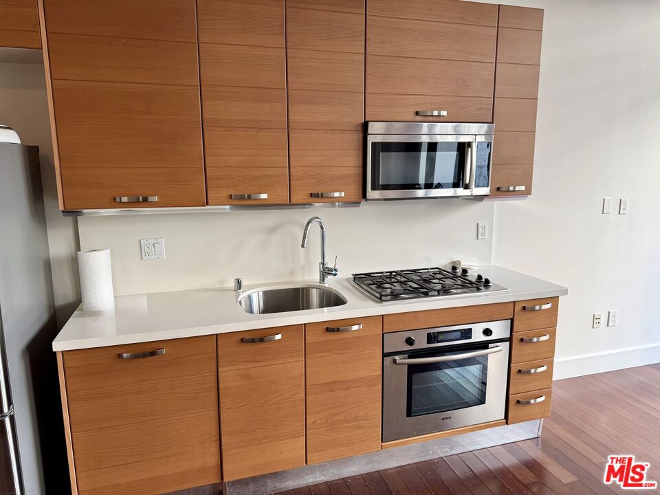 460 South Spring Street, Unit 205 Los Angeles, CA 90013 - Photo 17 of 18 a kitchen with stainless steel appliances a stove a microwave and sink