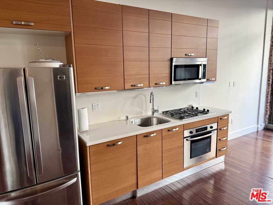 460 South Spring Street, Unit 205 Los Angeles, CA 90013 - Photo 2 of 18 a kitchen with stainless steel appliances a stove microwave and sink