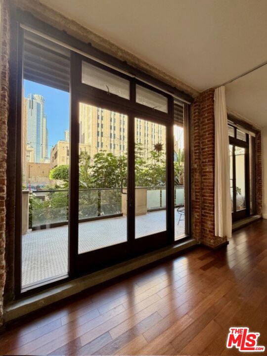 460 South Spring Street, Unit 205 Los Angeles, CA 90013 - Photo 2 of 10 a view of empty room with wooden floor and floor to ceiling window