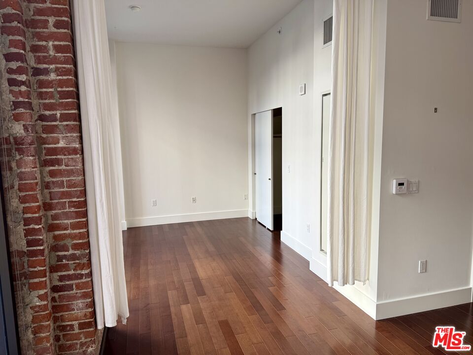 460 South Spring Street, Unit 205 Los Angeles, CA 90013 - Photo 9 of 18 a view of a hallway with wooden floor and staircase