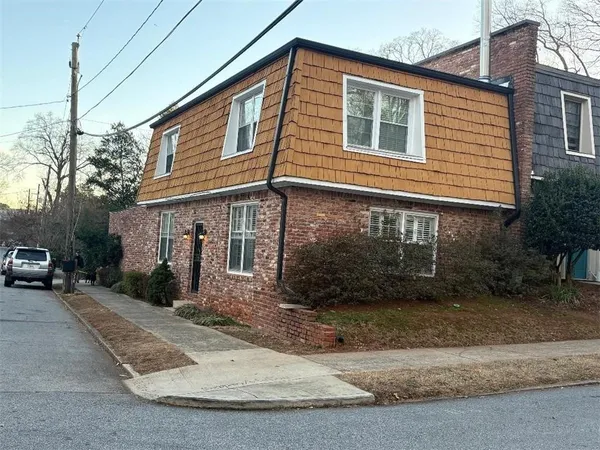 a view of a house with a yard and parking space