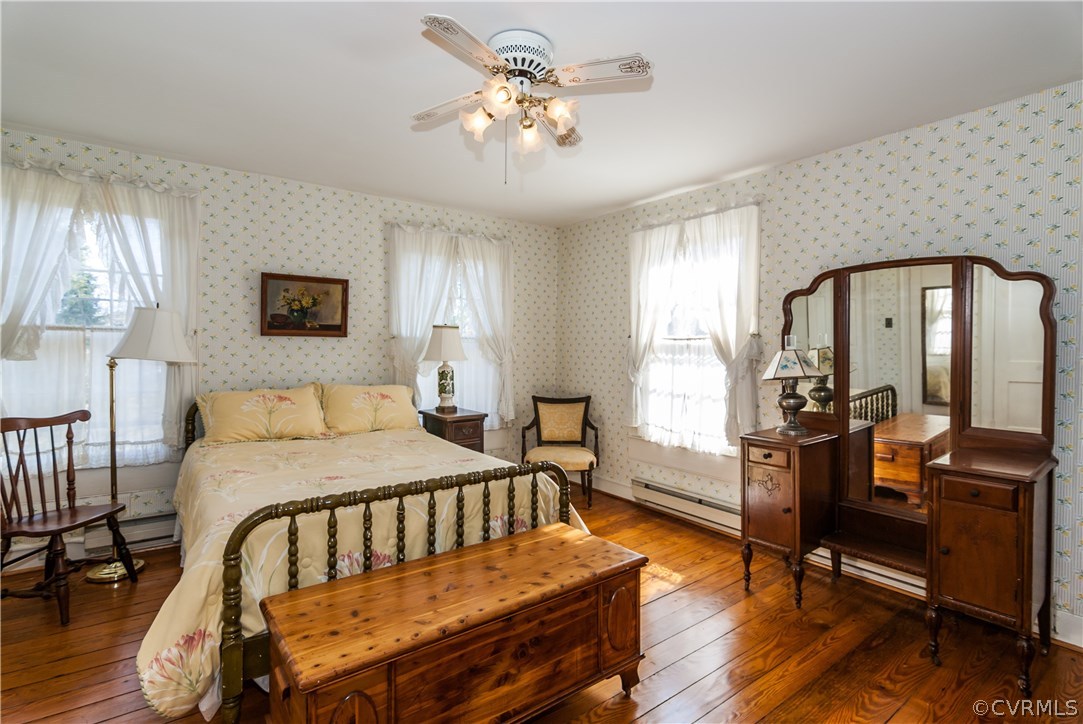11513 Beach Road Chesterfield, VA 23838 - Photo 19 of 29 a bedroom with a bed a dresser and wooden floor