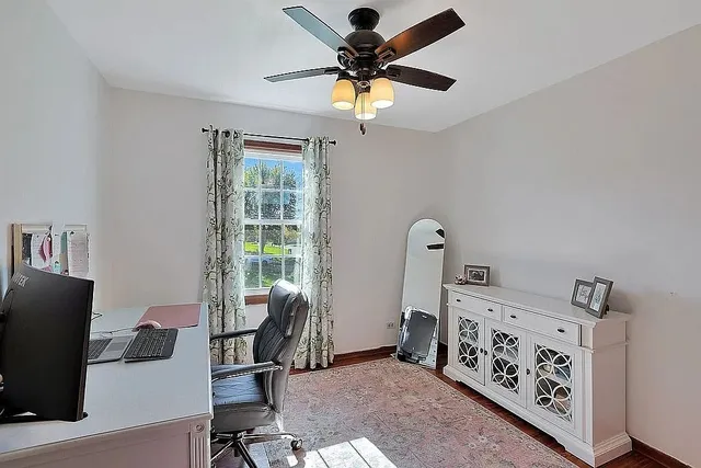 a view of a workspace with furniture and a window