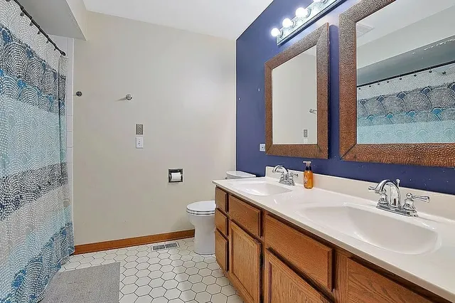 a bathroom with a sink a toilet and mirror