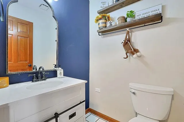 a bathroom with a sink a toilet and a mirror