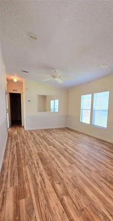 a big room with wooden floor and windows