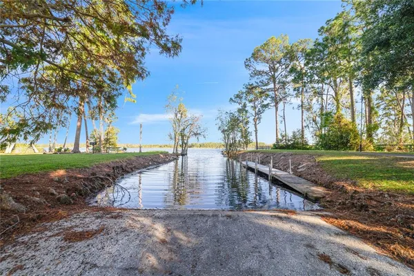 a view of a water pond with green yard
