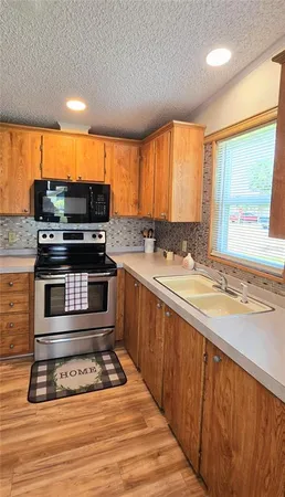 a kitchen with stainless steel appliances a stove sink and cabinets
