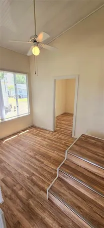 a view of empty room with window and ceiling fan