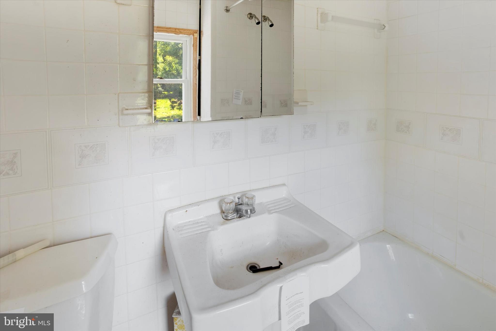 15526 Holly Grove Road Silver Spring, MD 20905 - Photo 13 of 19 a bathroom with a sink and a window