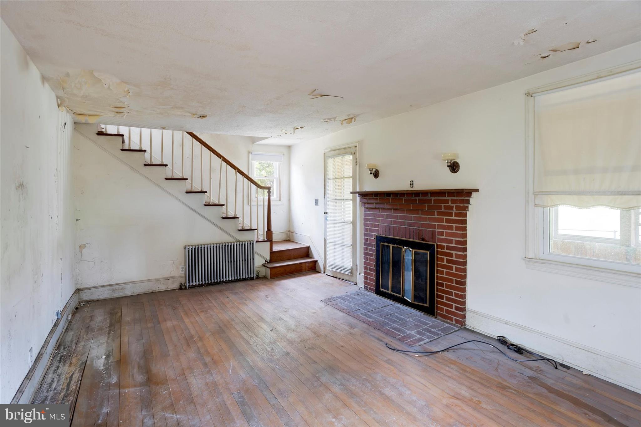15526 Holly Grove Road Silver Spring, MD 20905 - Photo 5 of 19 a view of an empty room with wooden floor fireplace and a window