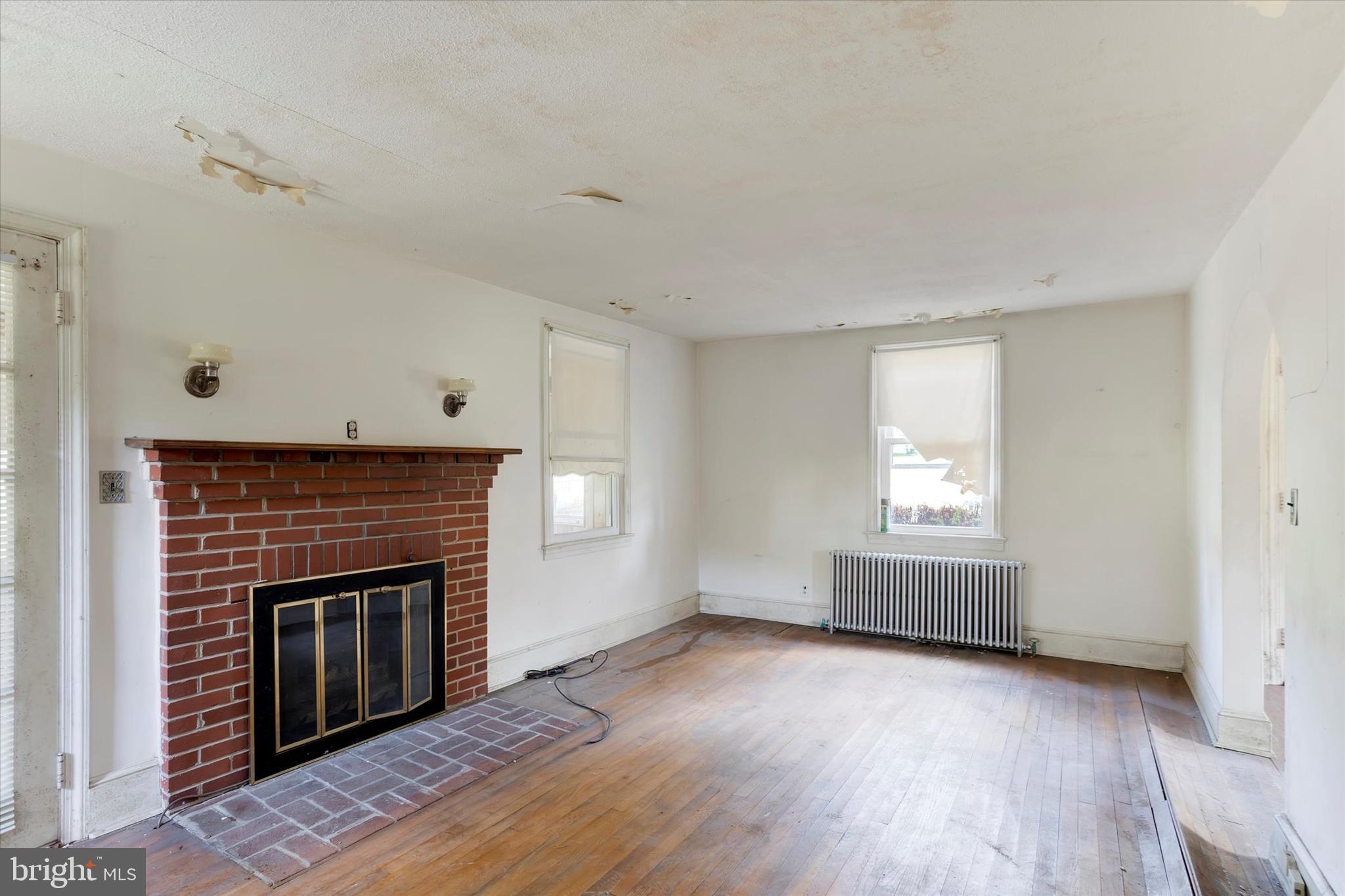 15526 Holly Grove Road Silver Spring, MD 20905 - Photo 6 of 19 a view of empty room with wooden floor and fireplace
