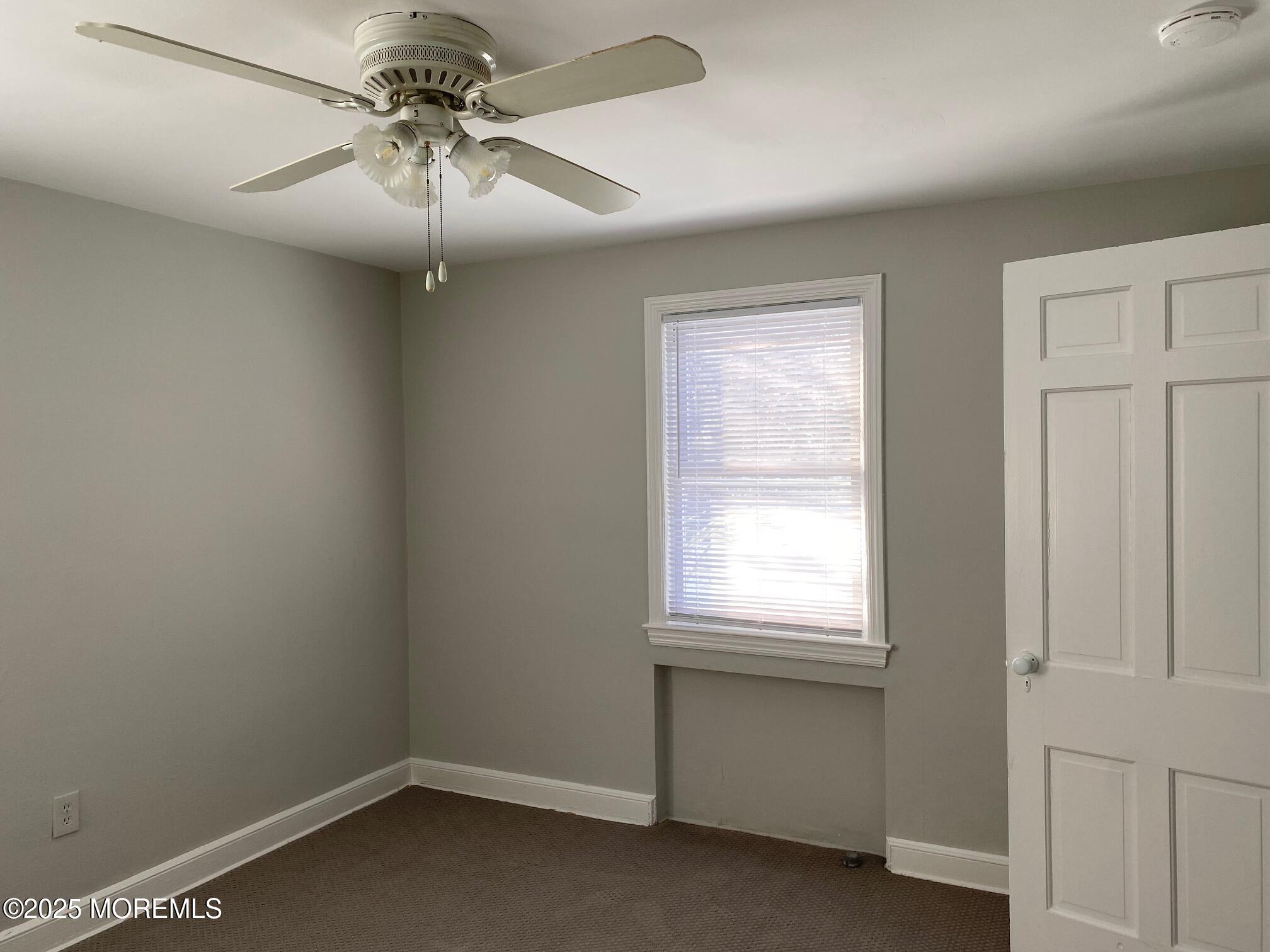 20 Oldfield Place Red Bank, NJ 07701 - Photo 8 of 11 an empty room with a window and a fan