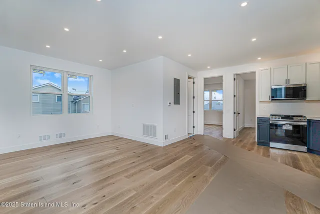 a view of kitchen with stainless steel appliances kitchen island wooden floor and window