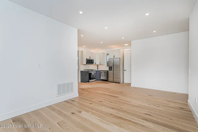 a view of an empty room with a kitchen