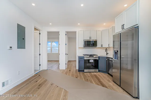 a kitchen with a refrigerator and a stove top oven