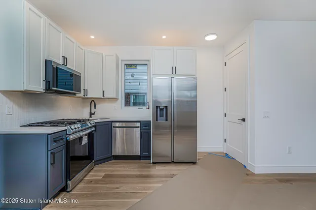 a kitchen with stainless steel appliances granite countertop a refrigerator and a stove top oven