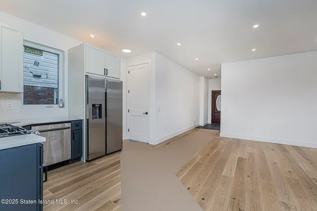 a view of kitchen with refrigerator stove and wooden floor