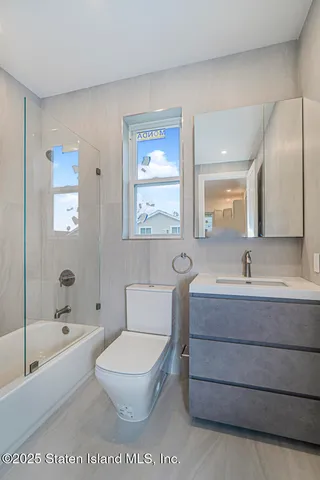 a bathroom with a toilet a sink a mirror and a bathtub