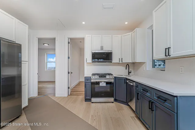 a kitchen with stainless steel appliances granite countertop a stove a refrigerator and a sink