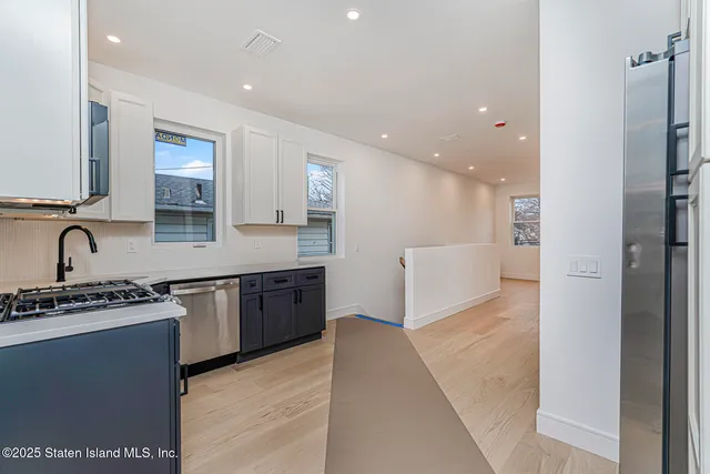 a kitchen with stainless steel appliances granite countertop a stove a sink and a refrigerator