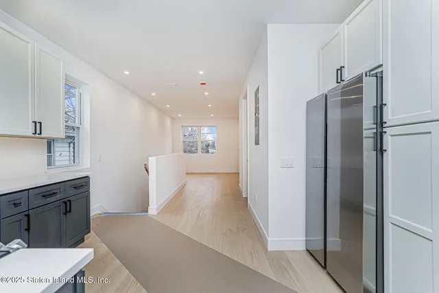 a view of a kitchen with a refrigerator and a sink
